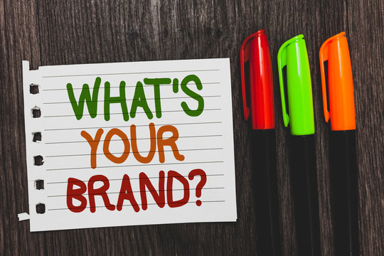 Handwriting Text What S Is Your Brand Question. Concept Meaning Define Individual Trademark Identify Company Colorful Words With White Page Red Green Orange Pen On Blackish Wooden Desk.