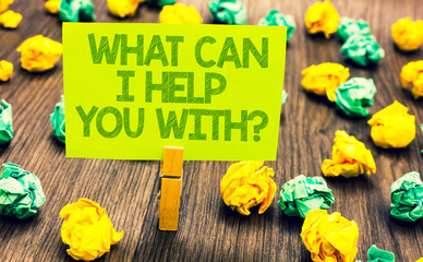 Handwriting text What Can I Help You With question. Concept meaning Offering assistance Experts advice ideas Paperclip retain written words yellow paper paper lobs laid on wooden floor.