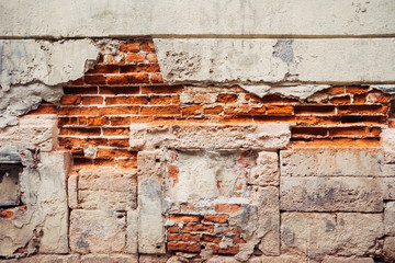 close-up of an old brick wall with ragged plaster