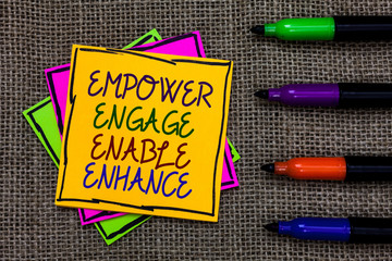 Text sign showing Empower Engage Enable Enhance. Conceptual photo Empowerment Leadership Motivation Engagement Written on some colorful sticky note 4 pens laid in rank on jute base.