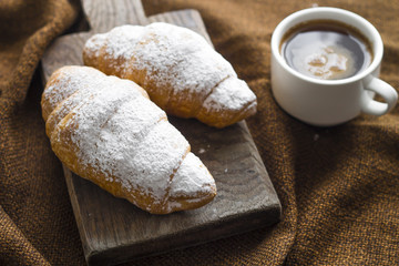 Freshly baked croissants with a cup of hot coffee. 
