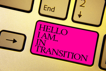 Word writing text Hello I Am.. In Transition. Business concept for Changing process Progressing planning new things Bright golden computer keyboard with pink button black color written texts.