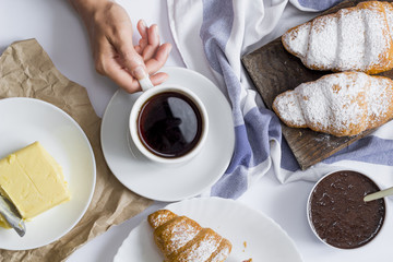 Breakfast with croissants, chocolate cream and coffee. 