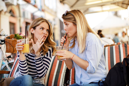 Two women gossiping in a cafe