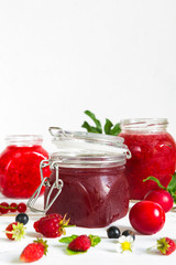Fototapeta na wymiar assortment of jams, seasonal fresh berries and fruits on white background