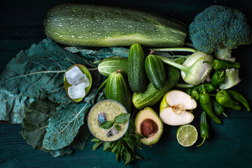 vegetarianism and a healthy lifestyle. green vegetables on a dark background. breakfast.Green vegetable drink-smoothie	