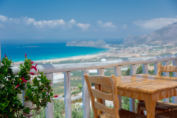 Wooden table in cafe with mountains and sea on background, Falassarna region, Crete, Greece