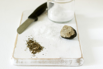 Ingredients for preparation of truffle salt, truffle and salt on a white background. Rustic style.
