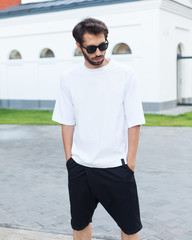 Fashionable man posing outdoors with background street