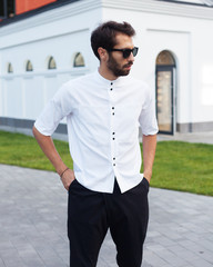 Youth street fashion for men. A man in a summer day in the street in a fashionable outfit. White...