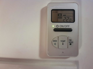 Electronic air conditioner control panel on a gray wall

