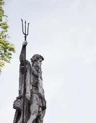 The ancient statue of the god of the seas and oceans Neptune (Poseidon). Famous tourist attraction  against a cloudy sky.
