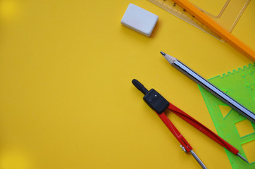 Back to school set in yellow. , notebook, pen, pencils, scissors, markers, chair, clip, glasses, compass, sharpener, eraser, autumn leaves