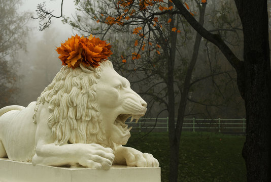 Marble sculpture of lion with garland on its head