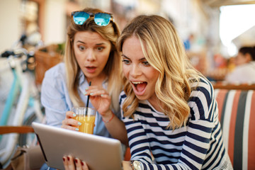 Two young women buying over the Internet via a digital tablet