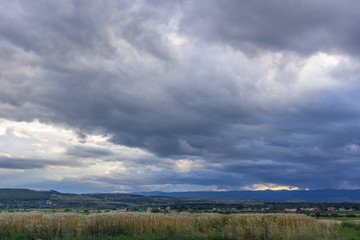Fototapeta na wymiar Stormy sky with clouds over the field