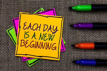 Text sign showing Each Day Is A New Beginning. Conceptual photo Every morning you can start again Inspiration Written on some colorful sticky note 4 pens laid in rank on jute base.