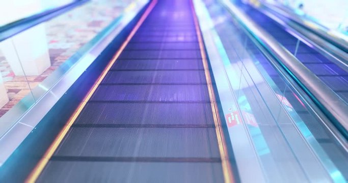 Modern shiny steel escalator moves on floor of airport hall