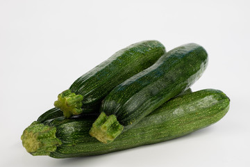 Zucchini on a white table. Tailor measure to measure the waist circumference during the diet.