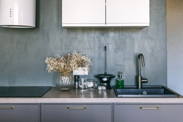 New stylish bright scandinavian interior details. Dark grey kitchen room organization. Pure water...
