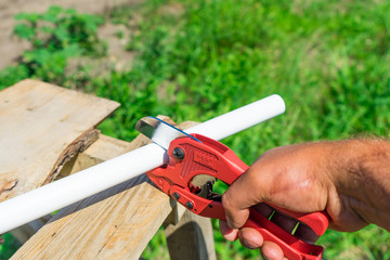 Picture of cutting plastic pipe by special red scissors