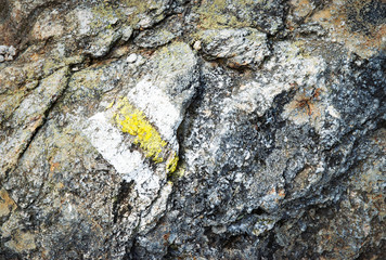 old yellow tourist sign on stone