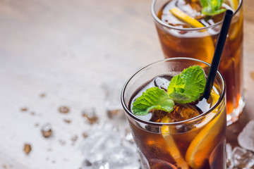 Traditional ice tea, chilled, with lemon, mint and ice on rustic table
