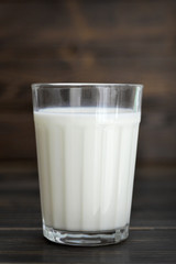 Glass of milk on wooden table
