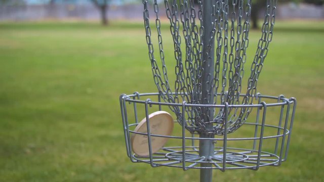 Slow-motion footage of a disc going into a frisbee golf basket.  Shot on a Blackmagic Ursa Mini Pro 4.6k with a Sigma 50-100mm f/1.8.