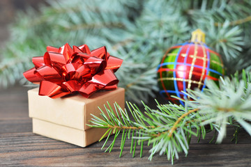 Christmas gift box with red bow on wooden background