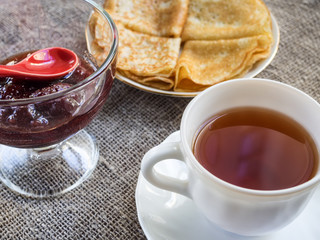 Tea with pancakes and jam.