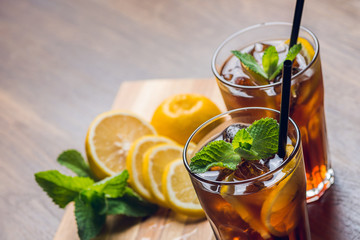 Traditional ice tea, chilled, with lemon, mint and ice on rustic table