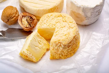 Fototapeten French AOC soft cow cheeses, crumbly Langres with washed rind structure, sharp Pie Angloys, camembert with strong taste and brie served as dessert after dinner © barmalini