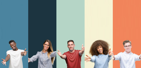 Group of people over vintage colors background looking at the camera smiling with open arms for hug. Cheerful expression embracing happiness.