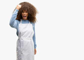 African american shop owner woman wearing an apron irritated and angry expressing negative emotion, annoyed with someone