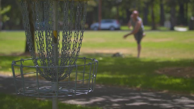 A man playing frisbee golf, taking a shot at the basket.  Shot on a Blackmagic Ursa Mini Pro 4.6k with a Sigma 50-100mm f/1.8.