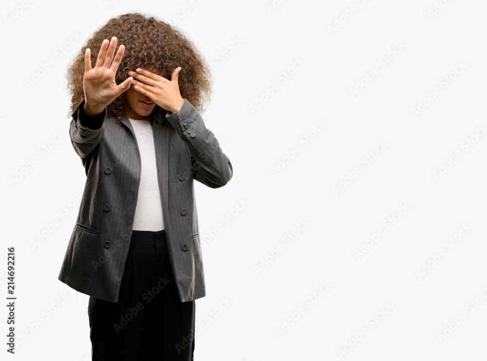 Sticker African american business woman wearing glasses covering eyes with hands and doing stop gesture with sad and fear expression. Embarrassed and negative concept.