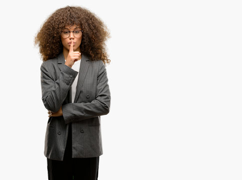 African american business woman wearing glasses asking to be quiet with finger on lips. Silence and secret concept.