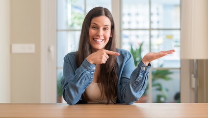 Young beautiful woman at home very happy pointing with hand and finger