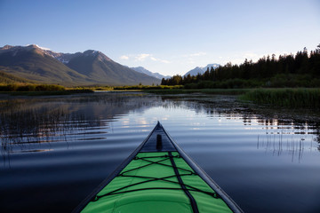 Kayaking in a beautiful lake surrounded by the Canadian Mountain Landscape. Taken in Vermilion...