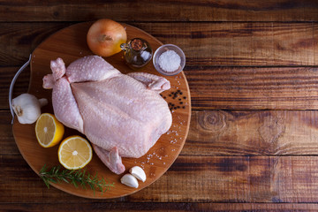 Raw chicken with herbs and spices, wooden rustic table, top view flat lay copy space