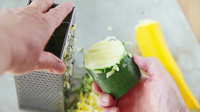 Point of view of woman using box grater to grate zucchini