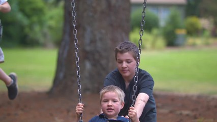 Slow-motion footage of a boy pushing his younger brother on a swing in a park.  Shot on a Blackmagic Ursa Mini Pro 4.6k with a Sigma 50-100mm f/1.8.