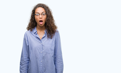 Beautiful young hispanic woman wearing glasses scared in shock with a surprise face, afraid and excited with fear expression