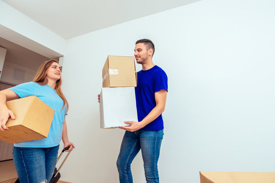Couple with cardboard boxes in new house. Young family moving in concept.