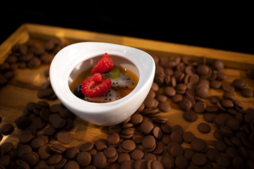 Sweet dessert with chocolate creme brulee topping with fresh raspberry serving in a small cup on chocolate candy