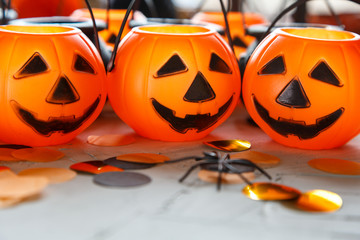 Halloween preparation. Decorative orange pumpkins and black cauldrons  on a gray grunge background. head jack lantern. Halloween concept.  