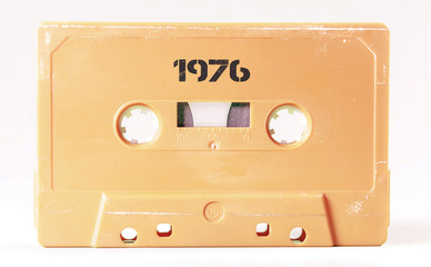 A vintage cassette tape from the 1980s era (obsolete music technology) with the text 1976 printed over it (my addition, not in the original image). Color: cream, sand. White background.
