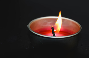 A burning candle in a dark background