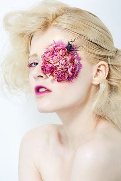 Blond young girl with flowers on face.